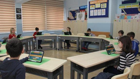 Bir sınıfta tabletlerle çalışan ilkokul öğrencileri
